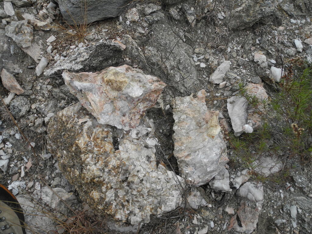 Ein aufgeschlagener Brocken enthält einen großen gelblichen Beryll-Kristall