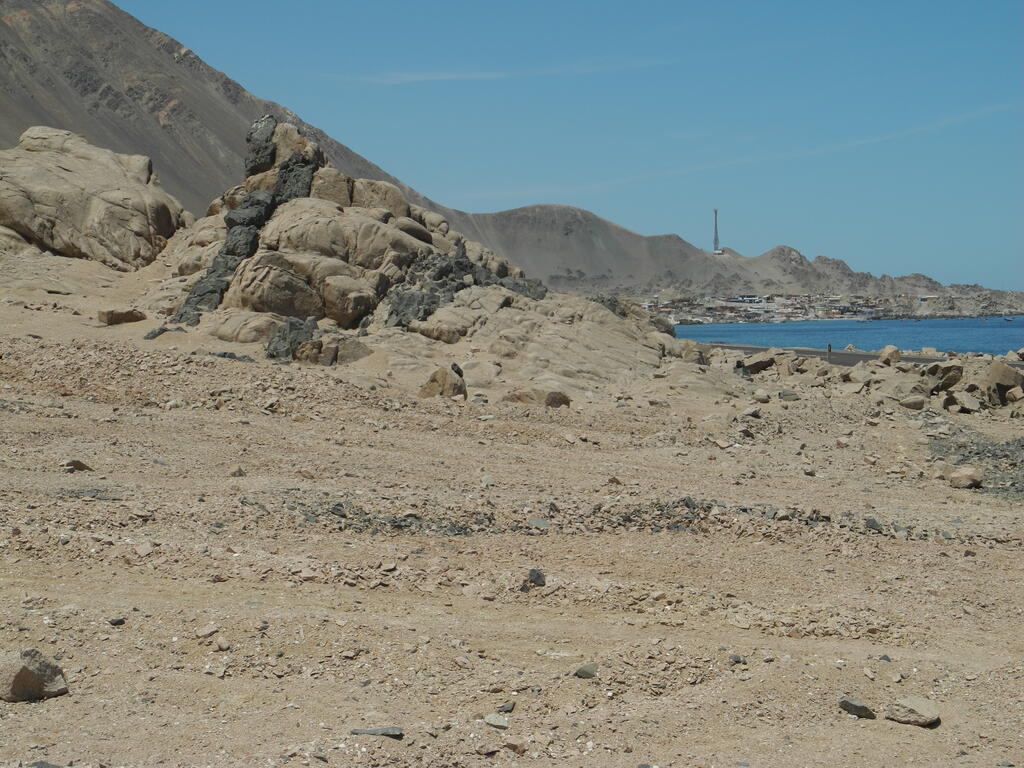 Felsen mit einem dunklen Gestein, das in einem helleren Gestein Gänge bildet