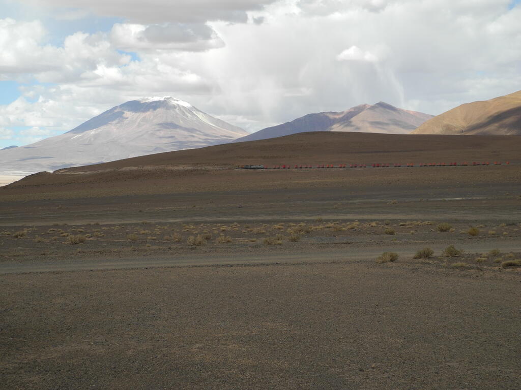 Zug der FCAB an der Station Carcote vor dem Vulkan Ollagüe